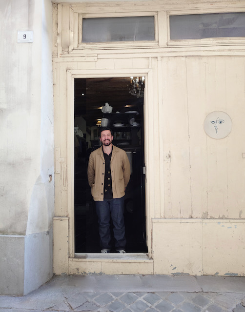 Charles, consultant IA, sur le pas d'une porte d'atelier